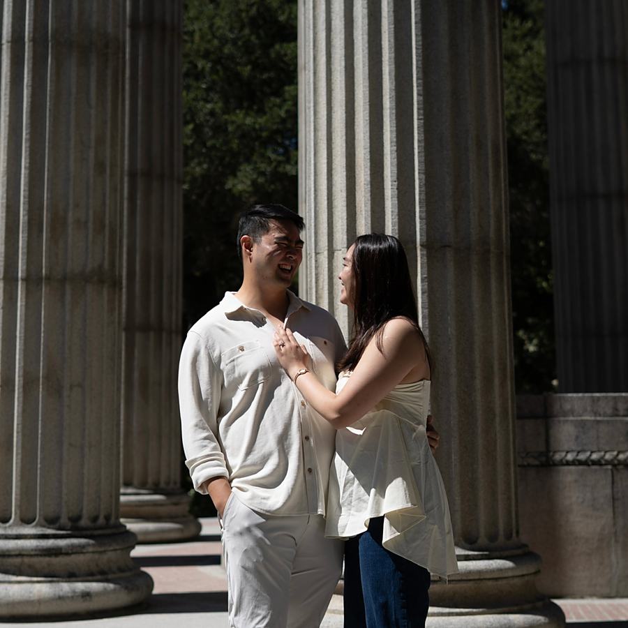 Ashley and Benjamin laughing beneath stone columns